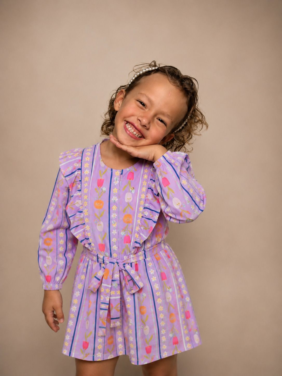Macaquinho infantil lilás com estampa floral exclusiva, babados e faixa de amarrar